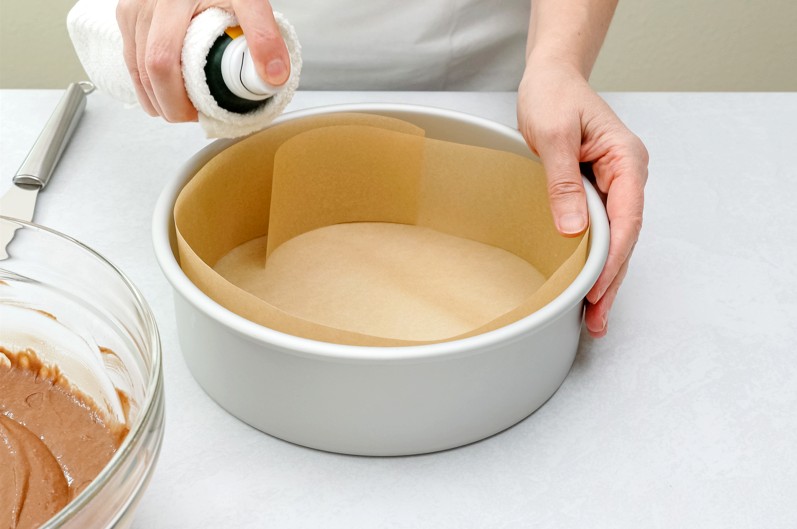 Baking spray sprayed onto parchment paper in baking pan