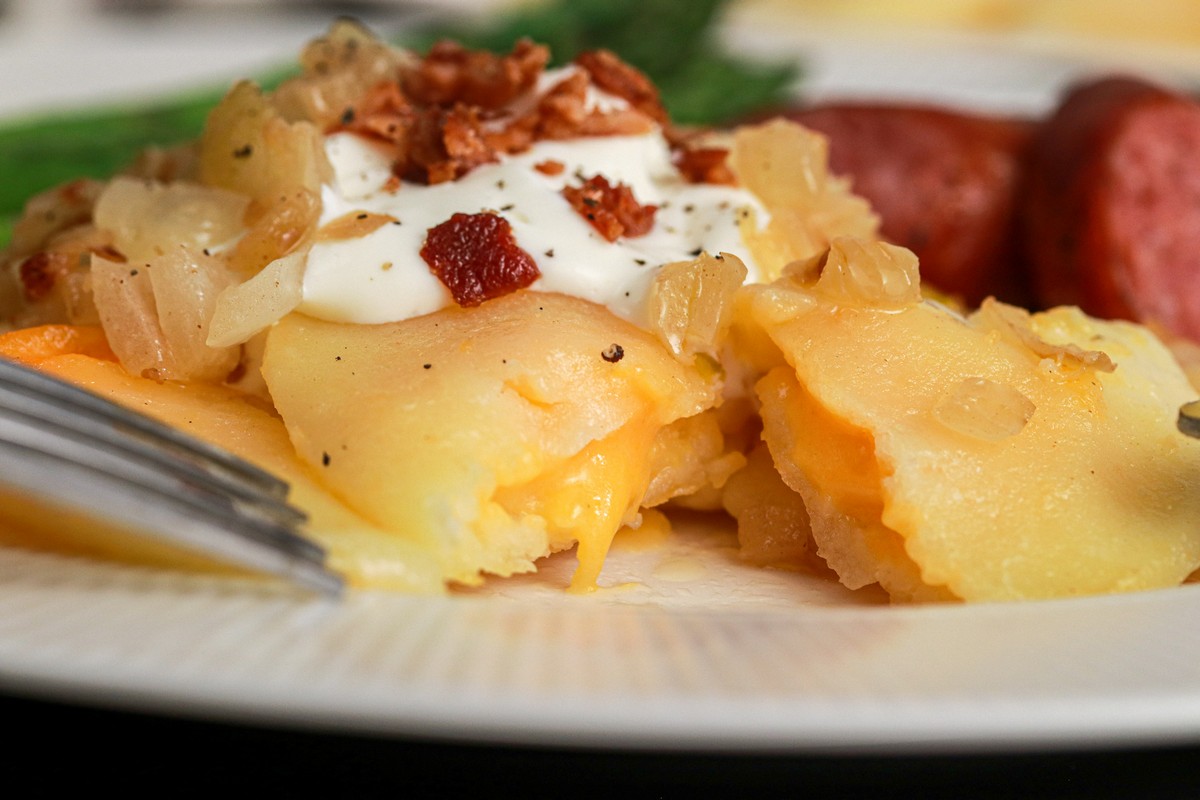 Gluten-free Cheddar Pierogies on dish surrounded by Ukrainian plates and casserole dishes